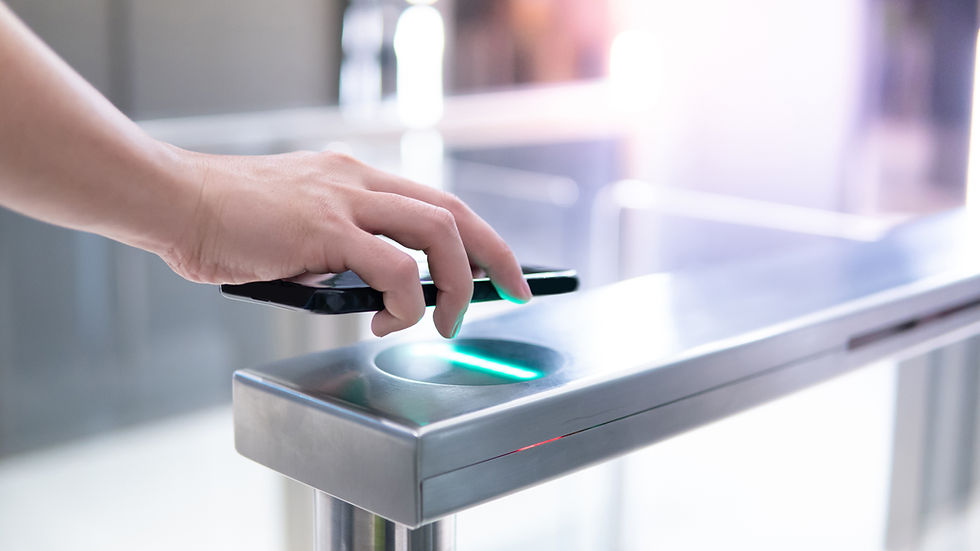 Hand scanning a smartphone over a turnstile sensor.